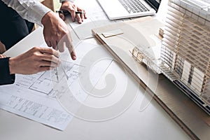 Engineering or Creative architect in construction project, Engineers hands working with compasses on construction blueprint build