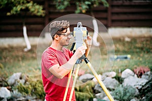 Engineering equipment with theodolite and total station in a garden at a construction site