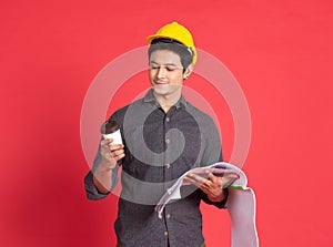 Engineering man with blueprint on rad background