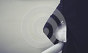 Engineering man holding a drawing paper and safety cap, in concept of engineering