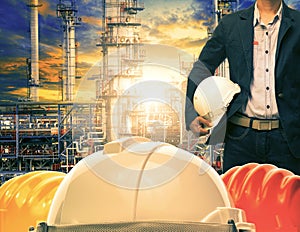 engineering man and safety helmet against oil refinery industries plant photo