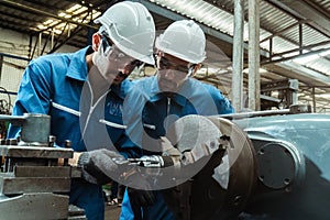 Engineering man wearing uniform safety workers perform maintenance in factory working machine lathe metal.