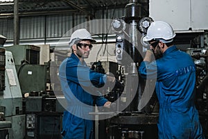 Engineering man wearing uniform safety workers perform maintenance in factory working machine lathe metal,.