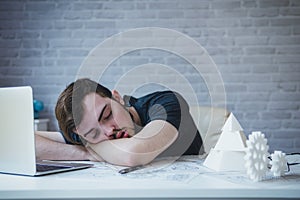 Engineering man working overwork and sleep on the desk with blue