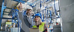 Engineering manager and mechanic worker doing routine check up in industrial factory