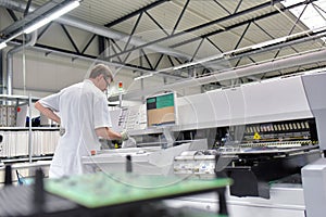 engineering in microelectronics: workers in the production and assembly of electronic high tech components in a modern factory