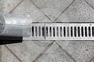 Engineering structure a downspout with a drainage grate.