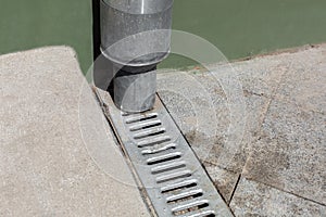 Engineering structure downspout pipe on green facade building.