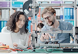 Engineering students using a 3D printer