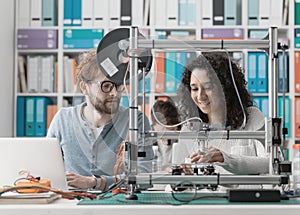 Engineering students using a 3D printer