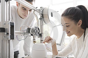 Engineering students using a 3D printer in the lab