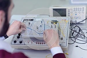 Engineering students working in the lab. Students are adjusting an electrical`s components inside lab