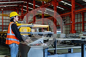 Engineering technician worker is operating the machine inside factory using touch screen computer monitor to command the order for