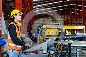 Engineering technician worker is operating the machine inside factory using touch screen computer monitor to command the order for