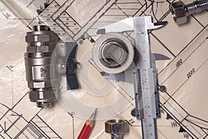 Engineering tools and plumbing details on a technical drawing. Caliper, pencil and ruler. View from above