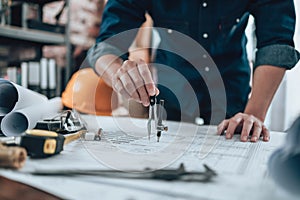 Engineering working with drawings inspection and writing on the office desk and Calculator, triangle ruler, safety glasses,