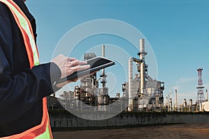 Engineering working hold tablet in front of oil refinery power station