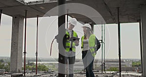 Engineers or architects have a discussion at construction site looking through the plan of construction. contre jour