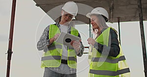 Engineers or architects have a discussion at construction site looking through the plan of construction. contre jour