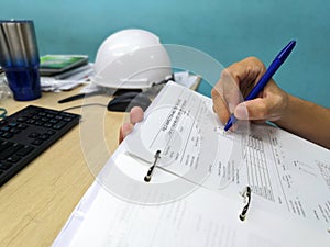 Engineer inspecting and checking datasheet.