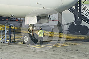 Engineers are checking the front wheels of the aircraft.