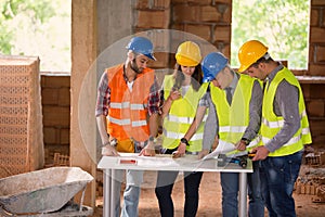 Engineers at construction site studying blue print