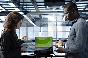 Engineers in data center using isolated screen mockup laptop