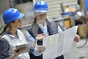 Engineers in industrial factory reading instructions