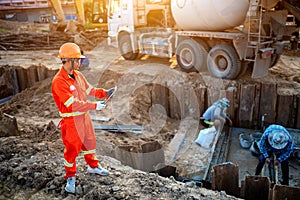 Engineers inspect the pouring of concrete