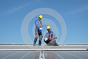 Engineers install solar cells on the roof of factory