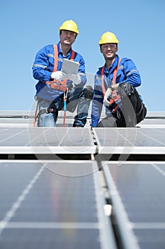 Engineers install solar cells on the roof of factory