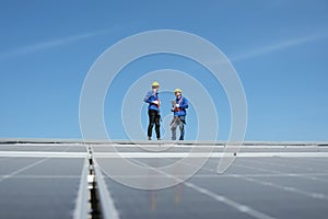 Engineers install solar cells on the roof of factory