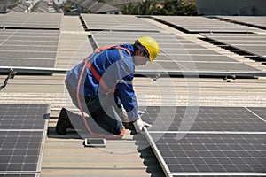 Engineers install solar cells on the roof of factory