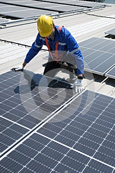 Engineers install solar cells on the roof of factory