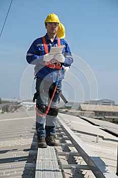 Engineers install solar cells on the roof of factory