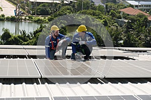 Engineers install solar cells on the roof of factory