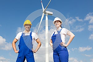 Engineers or installers posing in front of wind energy turbine