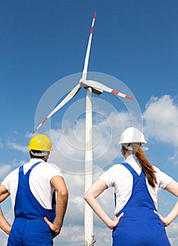 Engineers or installers posing in front of wind energy turbine