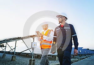 Engineers with investor walk to check the operation of the solar farmsolar panel systems, Alternative energy to conserve the