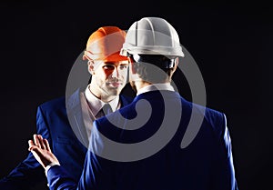 Engineers isolated on black background. Technical architect talks to project manager with unsatisfied face. Coworkers in