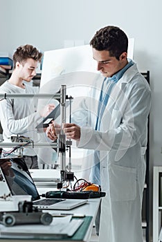 Engineers in the lab using a 3D printer