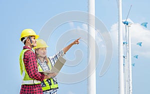 Engineers looking at wind turbine site with tablet