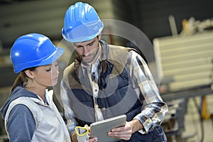 Engineers in metallurgic factory working on digital tablet