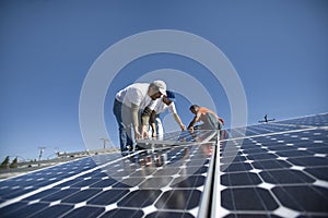 Engineers Placing Solar Panel Against Sky