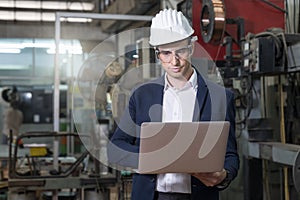 Engineers and skilled technicians are maintaining machinery. Professional technicians are using a laptop computer to control work
