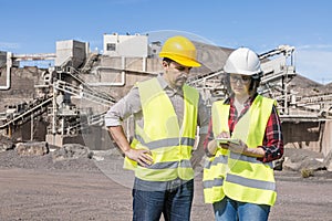 Engineers with tablet communicating on construction site photo