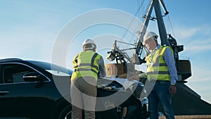 Engineers are talking about plans near a car and an industrial loader