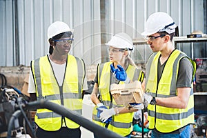 Engineers team mechanic using computer controller Robotic arm for welding steel in steel factory workshop. Industry robot