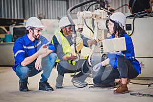 Engineers team mechanic using computer controller Robotic arm for welding steel in steel factory workshop. Industry robot