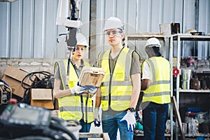 Engineers team mechanic using computer controller Robotic arm for welding steel in steel factory workshop. Industry robot